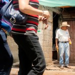 Don Erasmo habla con su esposa mientras se sientan afuera de su casa.