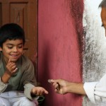 Julian gives some pesos to one of his grandchildren. Julian says that the Rivera's are a big family, with 300 relatives.